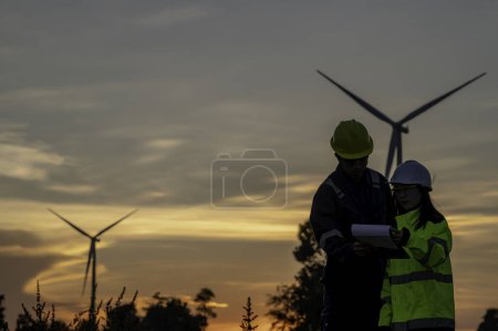 Foto de Dos ingenieros trabajando y sosteniendo el informe en el parque eólico Power Generator Station en la montaña. Tailandia gente. Técnico hombre y mujer discutir sobre el trabajo - Imagen libre de derechos