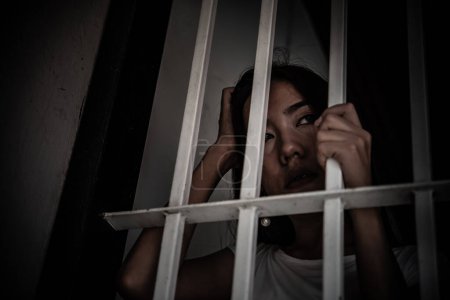Foto de Mujer desesperada por atrapar la prisión de hierro, concepto de prisionero. Tailandia gente. Espero ser libre. Si el violar la ley sería arrestado y encarcelado. - Imagen libre de derechos