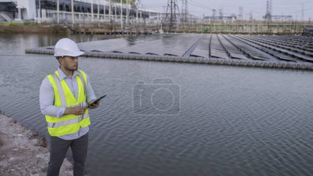 Foto de Ingeniero asiático trabajando en Floating solar farm. Energía renovable. Técnico e inversor panel solar comprobando los paneles en la instalación de energía solar - Imagen libre de derechos