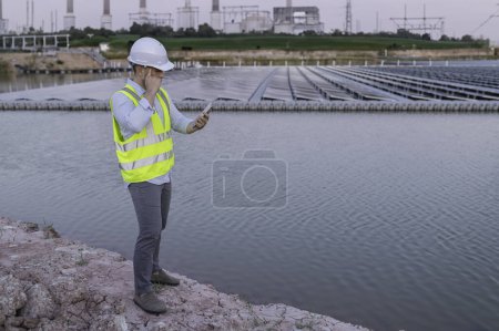 Foto de Ingeniero asiático trabajando en Floating solar farm. Energía renovable. Técnico e inversor panel solar comprobando los paneles en la instalación de energía solar - Imagen libre de derechos