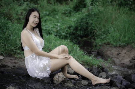 Téléchargez les photos : Portrait de femme asiatique sexy à la cascade, Se sentir frais à la rivière, Thai femelle se détendre au pays - en image libre de droit