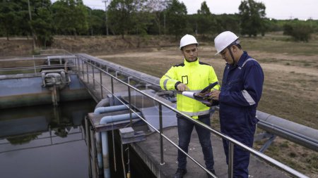 Téléchargez les photos : Ingénieurs de l'environnement travaillent dans les usines de traitement des eaux usées, Ingénierie de l'approvisionnement en eau travaillant à l'usine de recyclage de l'eau pour la réutilisation, Techniciens et ingénieurs discutent travailler ensemble. - en image libre de droit