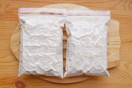 Téléchargez les photos : Tempeh Ready après la fermentation du soja dans des sacs perforés recouverts de mycélium blanc épais et dense - en image libre de droit