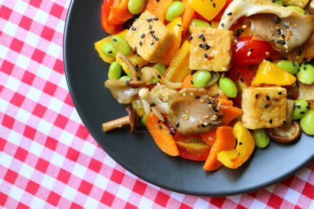 Téléchargez les photos : Assiette de salade de légumes colorés avec champignons huîtres et cubes de tempeh rôtis - en image libre de droit