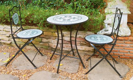 Téléchargez les photos : Table à thé en fer forgé et chaises dans le jardin - en image libre de droit