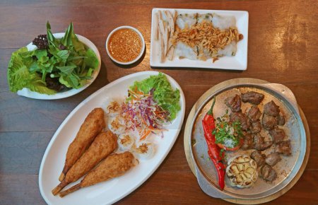 Photo for Delectable Popular Vietnamese Dishes Served on Wooden Table - Royalty Free Image