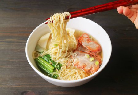 Photo for Hand Grabbing Delectable Chinese Egg Noodle with Chopsticks - Royalty Free Image