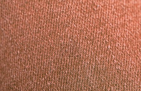 Téléchargez les photos : Gros plan de la texture de tissu de jean coloré brun rouge avec mise au point sélective - en image libre de droit