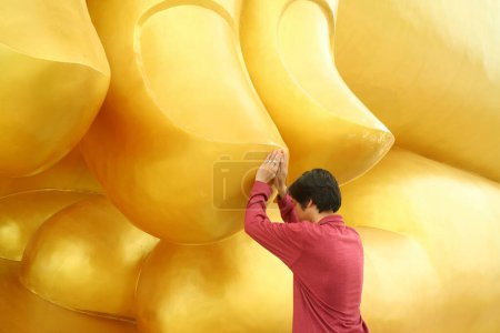 Foto de Hombre tocando el dedo del gran buda Imagen para la bendición, templo de Wat Muang, provincia de Ang Thong, Tailandia - Imagen libre de derechos
