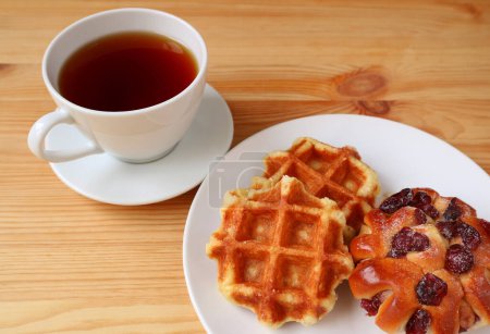 Photo for Belgian Waffles with a Cup of Hot Tea on Wooden Table - Royalty Free Image