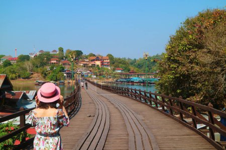 Mujer caminando en el Puente Lun, el puente de madera más largo de Tailandia en el distrito Sangkhlaburi, Kanchanaburi, Tailandia