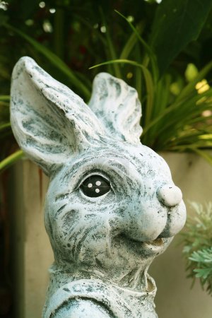 Gros plan d'un lapin de Pâques en pierre adorable Sculptures dans le jardin