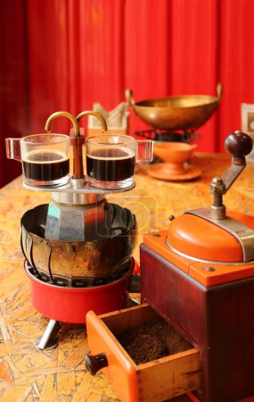 Zwei Tassen Espresso werden mit einer kleinen Kaffeemaschine im Retro-Stil gebraut