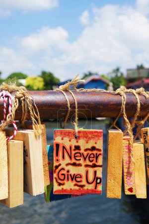 Wooden Plaque with Inspirational Quote Hanging on the Bridge Railing