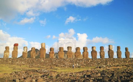Ein Teil der ikonischen riesigen Moai-Statuen auf der zeremoniellen Plattform Ahu Tongariki mit einem Besucher beim Fotografieren, Osterinsel, Chile, Südamerika