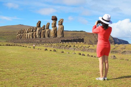 Weibliche Besucher schießen ein Bild der ikonischen fünfzehn Moai-Statuen der Ahu Tongariki Zeremonienplattform auf der Osterinsel, Chile, Südamerika