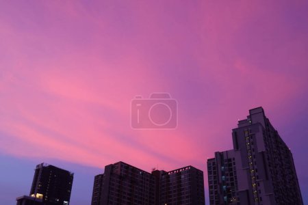 Erstaunlich lebhafter lila und rosafarbener Sonnenuntergang über der Stadt