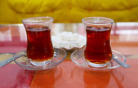Nahaufnahme eines Paares heißer türkischer Tee mit einem Teller Zuckerwürfel im Hintergrund