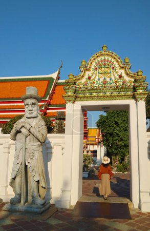 Chinesische Wächterstatue als Ballaststeine auf Schiffen vor Jahrhunderten neben dem verzierten Tor des buddhistischen Tempels Wat Pho, Bangkok, Thailand