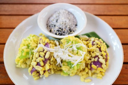 Leckeres Thai-Dessert namens Khanom Tua Pap, Klebriger Reis und Mungbohnen-Knödel mit Zucker und Sesam bestreut