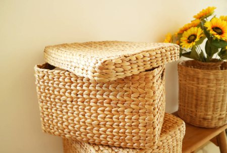 Summer home decor with stack of wicker boxes with bunch of sunflowers