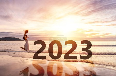 Téléchargez les photos : Jeune voyageuse à la recherche beau coucher de soleil sur la plage tranquille célébrant le Nouvel An 2023, concept de vacances d'été - en image libre de droit