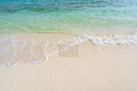 Schöner tropischer weißer Sandstrand mit Wellenschaum und transparentem Meer, Sommerurlaub und Reise-Hintergrund mit Kopierraum