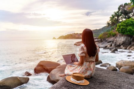 Young woman freelancer traveler working online using laptop while traveling on summer vacation, Freelance and workation concept