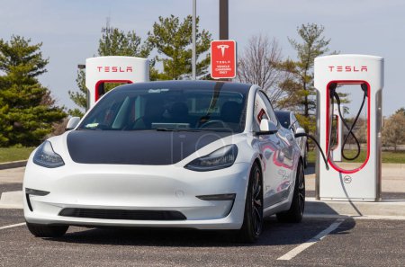 Foto de Lafayette - Circa abril 2023: Tesla EV carga de vehículos eléctricos. Productos Tesla incluyen coches eléctricos, almacenamiento de energía de la batería y paneles solares. - Imagen libre de derechos