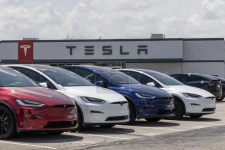 Foto de Indianápolis - 4 de julio de 2023: Tesla EV vehículos eléctricos en exhibición. Los productos Tesla incluyen coches eléctricos, almacenamiento de energía de la batería, paneles solares y una red de carga de vehículos eléctricos. - Imagen libre de derechos