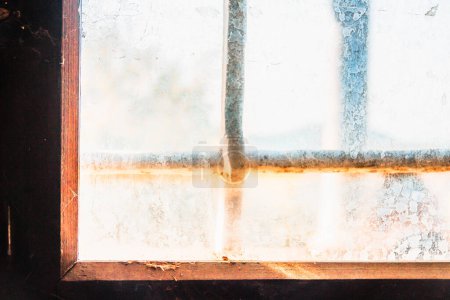 Téléchargez les photos : Rayons de soleil entrant par la vieille fenêtre sombre avec du verre de suie - en image libre de droit