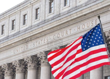 American flag waving in the wind in front of United States Court House in New York, USA