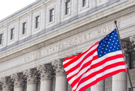 Bandera nacional de Estados Unidos ondeando en el viento frente a United States Court House en Nueva York, Estados Unidos