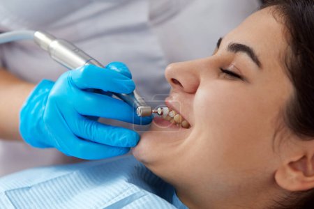 Photo for Young woman getting her teeth polished in modern dental clinic - Royalty Free Image