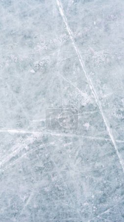Eishintergrund mit Spuren aus Eislaufen und Eishockey. blaue Textur
