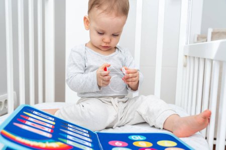 Joy of early childhood learning with a baby interacting with a Montessori busy book in a crib, perfectly blending the concepts of smart books and modern educational toys for early development