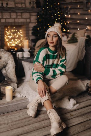 Photo for Fashion photo of beautiful woman with dark hair in elegant cozy clothes posing near decorated Christmas tree - Royalty Free Image