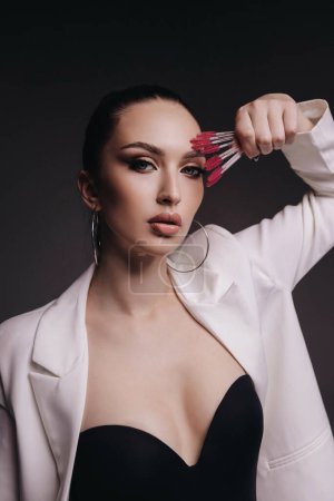 Téléchargez les photos : Fashion photo of beautiful woman with dark hair in medical gloves posing in studio with cosmetologist tools - en image libre de droit
