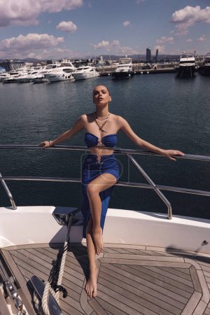 fashion outdoor photo of beautiful sexy woman with dark hair in elegant clothes posing on luxurious yacht