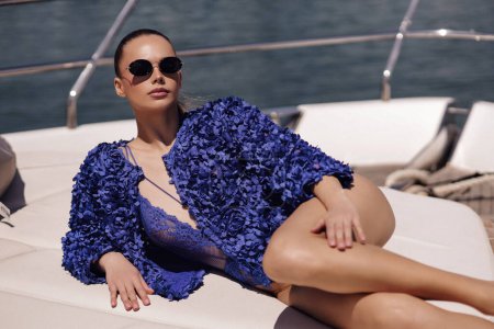 Téléchargez les photos : Mode photo extérieure de belle femme sexy avec les cheveux foncés dans des vêtements élégants posant sur yacht de luxe - en image libre de droit