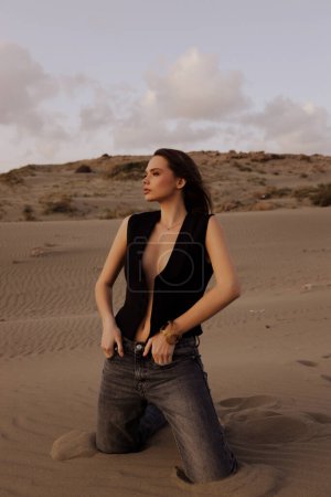 Téléchargez les photos : Mode photo en plein air de belle femme sexy avec les cheveux foncés dans des vêtements décontractés posant dans l'endroit à Chypre, qui ressemble à un désert - en image libre de droit