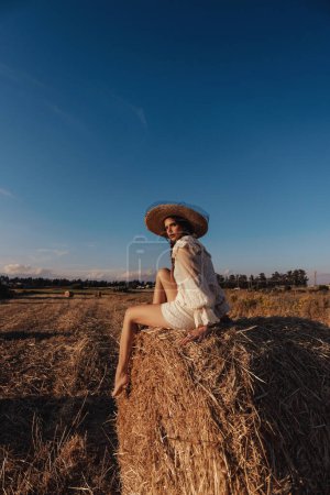 Photo for Fashion outdoor photo of beautiful woman with dark hair posing in hayloft - Royalty Free Image
