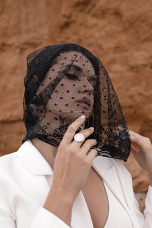 Téléchargez les photos : Portrait extérieur de mode de belle femme aux cheveux foncés avec voile noir sur le visage - en image libre de droit