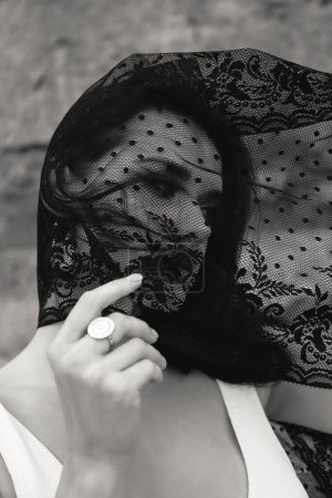 Téléchargez les photos : Portrait extérieur de mode de belle femme aux cheveux foncés avec voile noir sur le visage - en image libre de droit