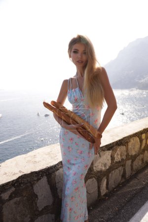 Téléchargez les photos : Photo de voyage de belle femme aux cheveux blonds dans des vêtements élégants posant près d'une voiture rétro jaune sur la côte amalfitaine à Positano - en image libre de droit