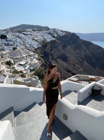 Photo for Fashion outdoor photo of beautiful woman with dark hair in elegant clothes with accessory traveling around Santorini island - Royalty Free Image