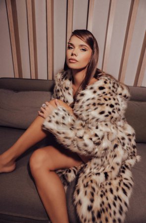 Photo for Fashion photo of beautiful woman with dark hair in luxurious lynx fur coat posing in elegant interior - Royalty Free Image
