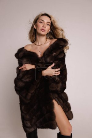 Photo for Fashion photo of beautiful sexy woman with blond hair in luxurious fur coat posing in the studio - Royalty Free Image