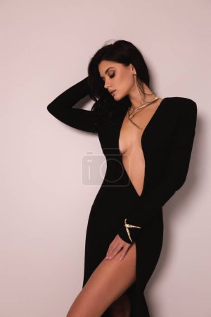Photo for Fashion photo of beautiful woman with dark hair in luxurious sexy black dress posing in the studio - Royalty Free Image