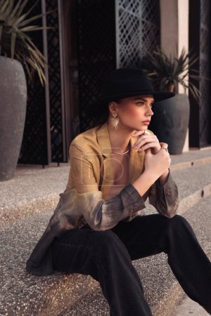 Photo for Fashion outdoor photo of beautiful slavic woman with dark hair in casual clothes and black hat posing in the street of Limassol - Royalty Free Image